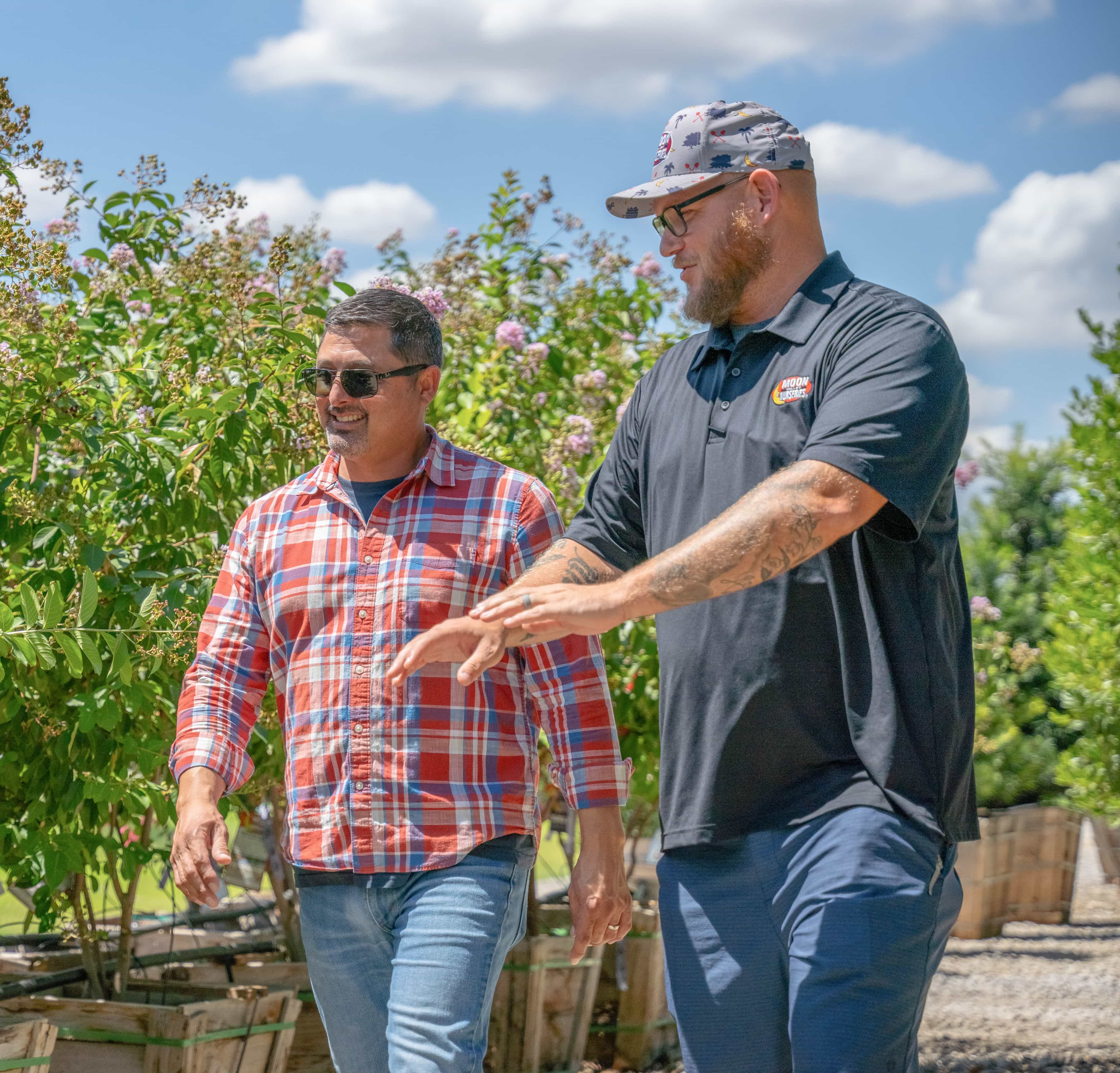 Sales staff with customer walking through nursery